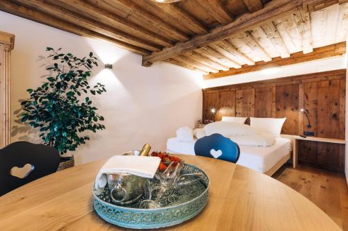 um quarto com duas camas e uma mesa com uma tigela de fruta em Amplatz 1523 - B&B and Suites em Montagna