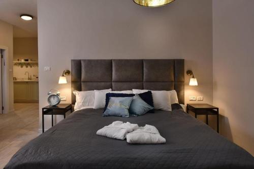 a bedroom with a large bed with two towels on it at הקצה- The Edge in Sifsufa