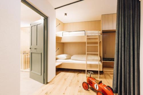a small bedroom with bunk beds and a red toy car at Amplatz 1523 - B&B and Suites in Montagna
