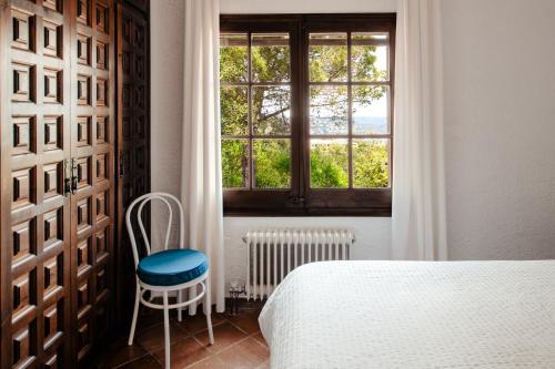 a bedroom with a bed and a window and a chair at Villa Ventisca in Platja  d'Aro
