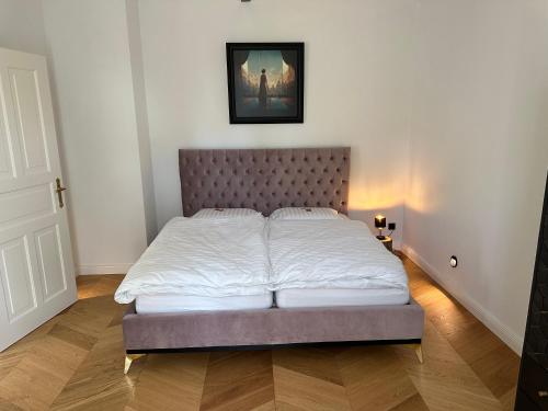 ein Schlafzimmer mit einem großen Bett mit weißer Bettwäsche in der Unterkunft Villa Schuwardt auf Nordend in Rathenow