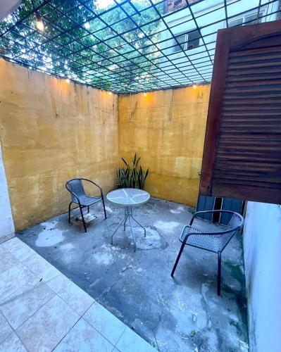 un patio con 2 sillas y una mesa en una habitación en Departamento Perú en Corrientes