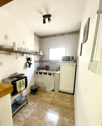 una pequeña cocina con fregadero y microondas en Departamento Perú en Corrientes