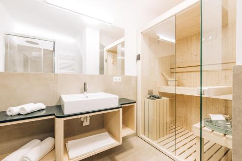ein Bad mit einem Waschbecken und einem Spiegel in der Unterkunft Amplatz 1523 - B&B and Suites in Montan