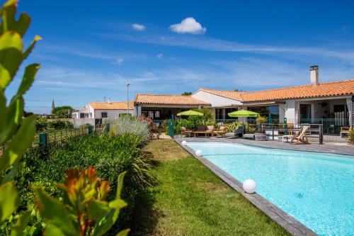 une villa avec une piscine et une maison dans l'établissement Hôtel Les Vignes de la Chapelle, "The Originals Relais", à Sainte-Marie de Ré