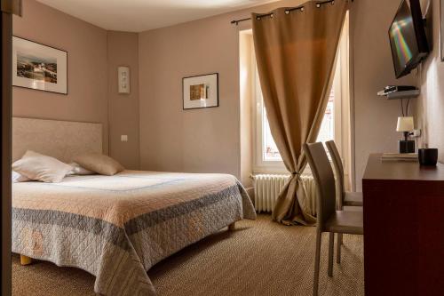sypialnia z łóżkiem, biurkiem i oknem w obiekcie L'Edgar w mieście Port-Lesney