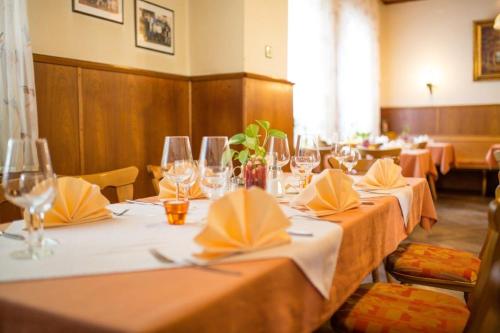 a row of tables with wine glasses and napkins at Hotel-Restaurant Wiendl in Regensburg