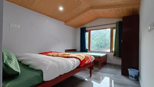 1 dormitorio con cama y ventana en The Hostelers Homestay - Near ISBT, Bypass, Advance Study and HPU Simla en Shimla