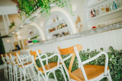 a row of white chairs sitting at a bar at Spacious One Bedroom Apartment in Caesar Resort & SPA, Long Beach in Perivolia tou Trikomou