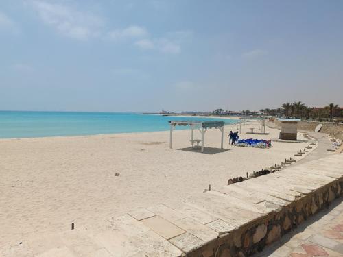 uma praia de areia com um parque infantil e o oceano em lazorde Bay em El Alamein