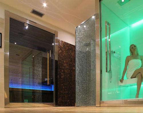 a woman in a white dress sitting in a shower at Hotel Aquila D'Oro in Misano Adriatico