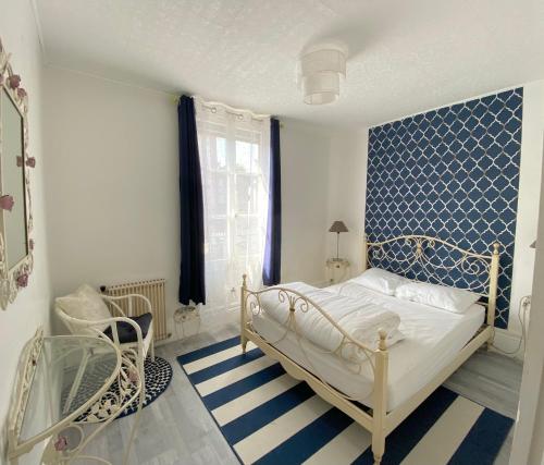 a bedroom with a white bed and a blue wall at L’ardoisière in Honfleur