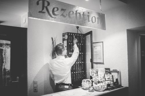 a man is standing at a counter in a store at Hotel-Restaurant Wiendl in Regensburg
