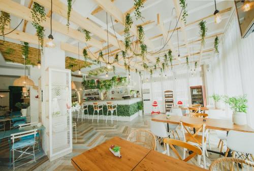 a restaurant with wooden tables and chairs and plants at Spacious One Bedroom Apartment in Caesar Resort & SPA, Long Beach in Perivolia tou Trikomou