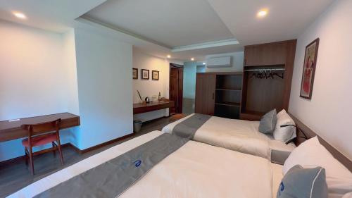 a hotel room with two beds and a desk at Sapa Eco Villas & Spa in Sa Pa