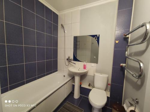 y baño con lavabo, aseo y bañera. en Уютная однокомнатная квартирка, в тихом спальном районе, недалеко от Аэропорта en Almaty