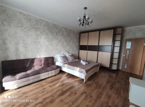 a living room with a couch and a bed at Уютная однокомнатная квартирка, в тихом спальном районе, недалеко от Аэропорта in Almaty