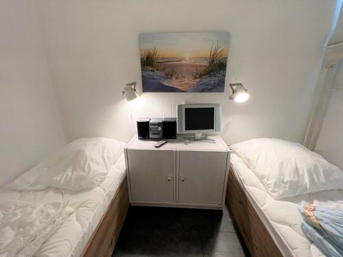 um quarto com 2 camas e um computador numa secretária em Ferienpark Sierksdorf App 531 - Strandlage em Sierksdorf
