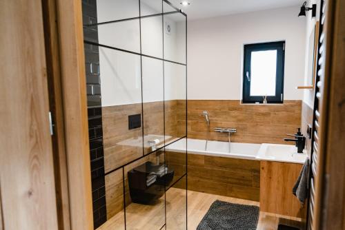 a bathroom with a glass shower and a sink at NOVMI - Domki letniskowe 