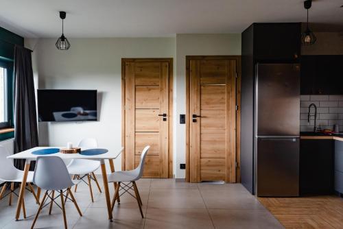 a kitchen and dining room with a table and chairs at NOVMI - Domki letniskowe 