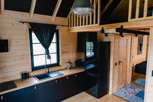 a kitchen in a log cabin with a sink and a window at NOVMI - Domki letniskowe 