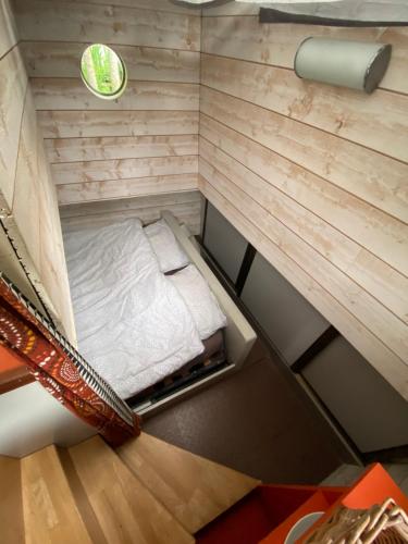 Cette petite chambre offre une vue de tête sur un lit. dans l'établissement Péniche hollandaise cosy, à Dole