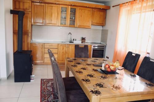Krivoglavci的住宿－Villa Sarajevo, Vogosca，一间带木桌的厨房和一间餐厅