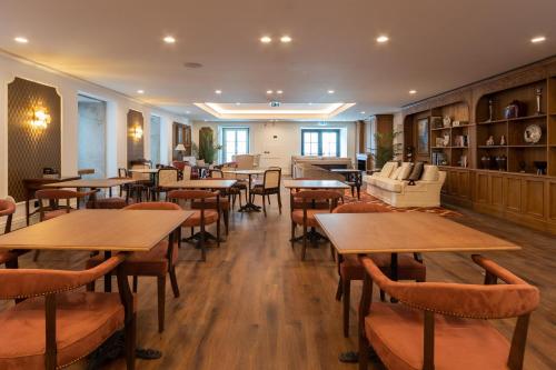 a restaurant with tables and chairs and a couch at AP Dona Aninhas in Viana do Castelo