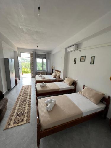 a room with three beds and a couch at KAFUL APARTMENTS in Qeparo