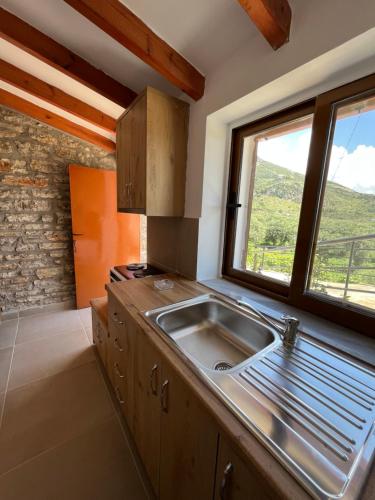 a kitchen with a sink and a window at KAFUL APARTMENTS in Qeparo