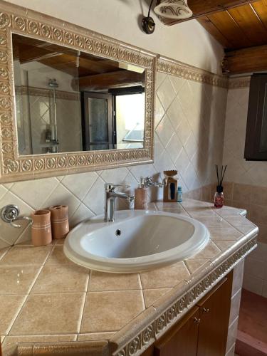 La salle de bains est pourvue d'un lavabo et d'un miroir. dans l'établissement Nikuzza Holiday House, à Noto