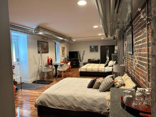 a bedroom with two beds and a brick wall at Historical Oscar Lofquist house in the heart of Des Moines in Des Moines