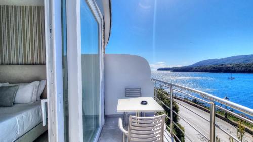 a balcony with a bed and a view of the water at Hotel Plaza in Porto Azzurro