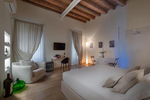 1 dormitorio con 1 cama blanca y sala de estar en Massimago Wine Suites, en Verona