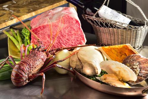a table with a plate of meat and vegetables at Hotel Nikko Fukuoka in Fukuoka