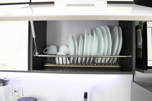 a shelf with white dishes in a kitchen at Mio Loft - Vista El Poblado Free Parking Recepción 24h High Internet in Medellín