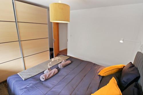 a bedroom with a bed with pink slippers on it at Magnifique appartement au coeur des 4 Vallées in Les Collons