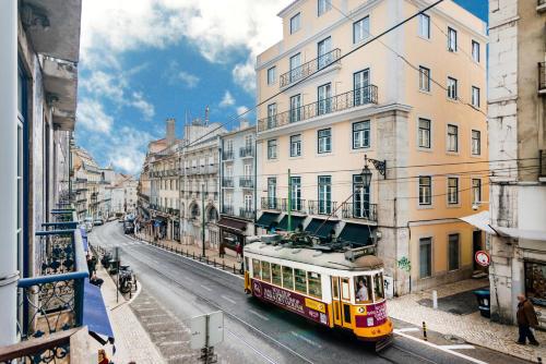 リスボンにあるChiado Mercy IIの建物のある街路を走るバス
