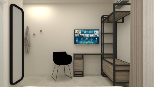 a room with a chair and a television on a wall at Roula's house on the beach in Skiathos Town