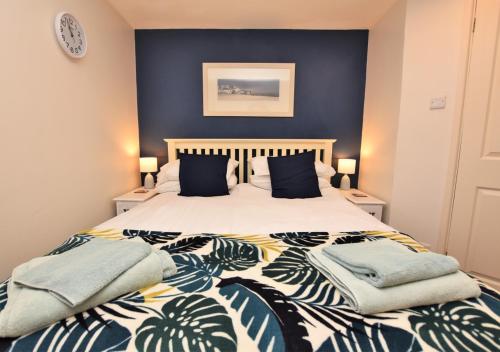 a bedroom with a large bed with blue walls at 2a Mariners Apartments in St Ives