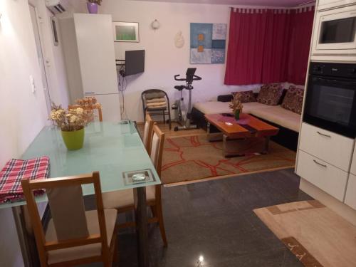 a kitchen and living room with a table and a couch at D,apartman' ulica pušća 51, 51513 Omišalj in Omišalj