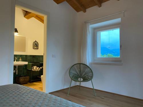 a bedroom with a chair and a window at B&B Casa Trambasore in Caprino Veronese