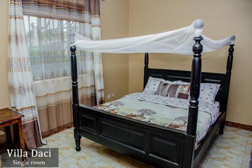 a bedroom with a black bed with a canopy at Villa Daci in Gulu