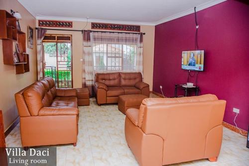 a living room with leather furniture and a purple wall at Villa Daci in Gulu