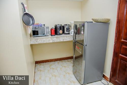 a kitchen with a stainless steel refrigerator in a room at Villa Daci in Gulu