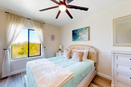 um quarto com uma cama e um ventilador de teto em The Southern Retreat em Tucson