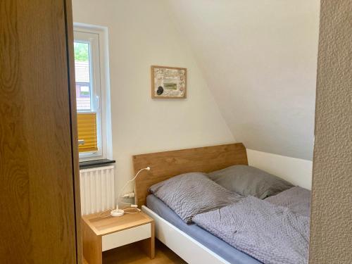 um pequeno quarto com uma cama e uma mesa em Haus Wilhelmi Wilhelmi Whg 3 em Wangerooge