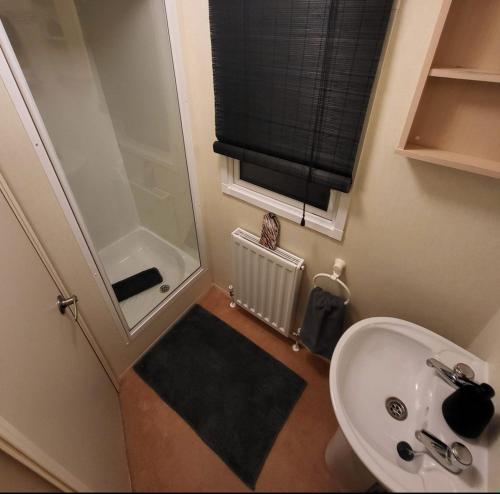 a small bathroom with a sink and a shower at FAB Caravan Holiday Home in Colmonell