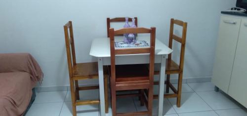 einen Tisch mit 2 Stühlen, einem Tisch, einem Tisch und Stühlen in der Unterkunft Matinhos 150 metros da praia in Matinhos