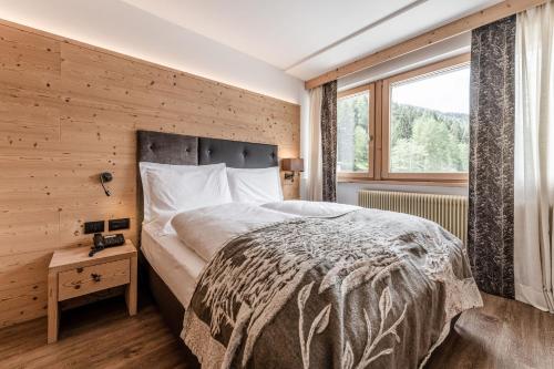 a bedroom with a large bed and a window at Ravelli Sporting in Mezzana